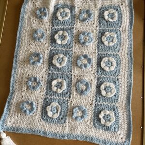 A photo of a baby blanket with blue and white flowers