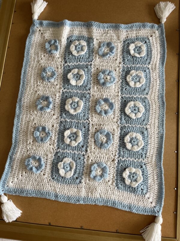 A photo of a baby blanket with blue and white flowers