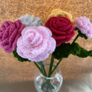 a vase of crochet roses in multicolours