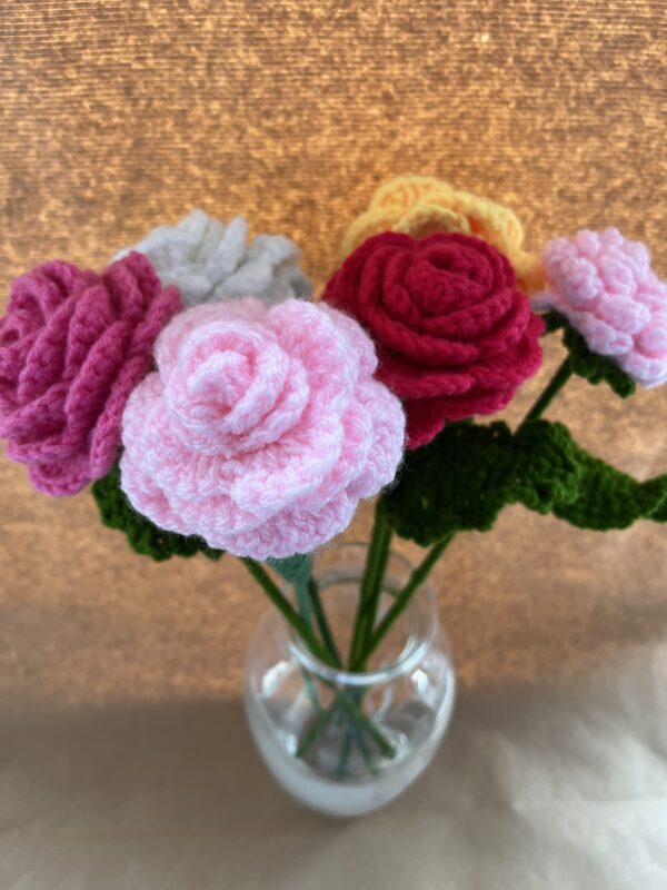 a vase of crochet roses in multicolours