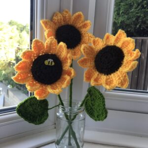 A photo of three handmade crochet sunflowers