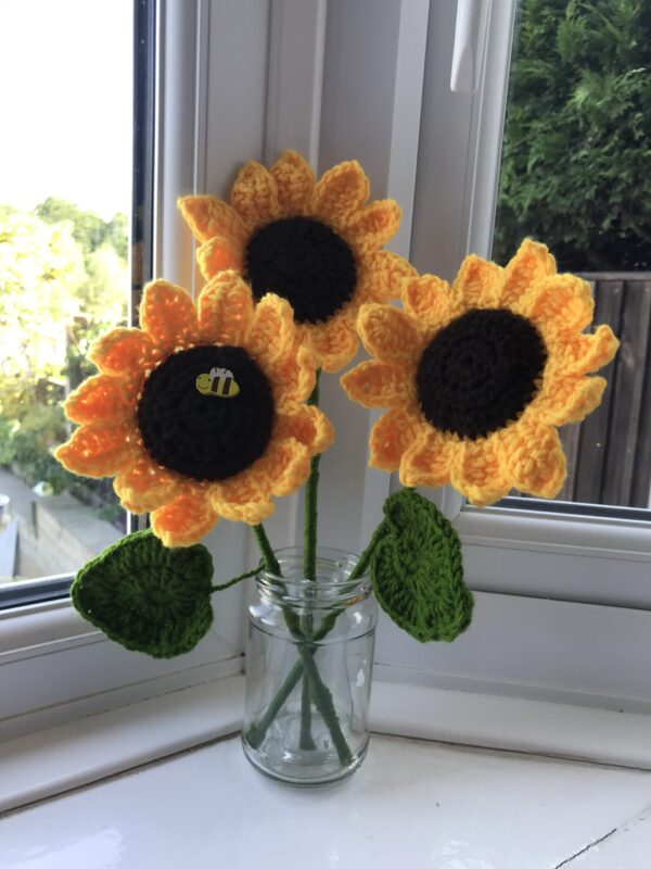 A photo of three handmade crochet sunflowers